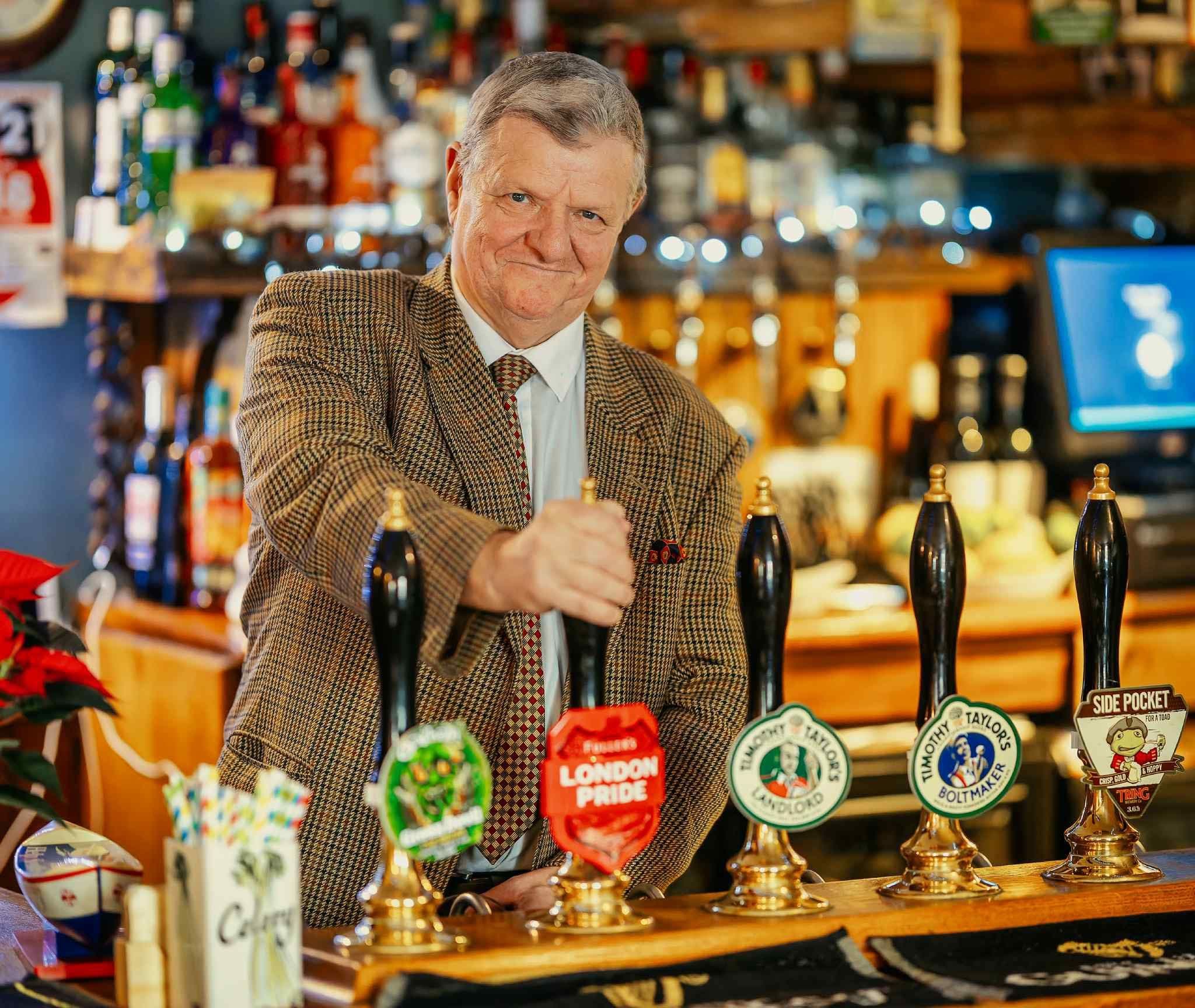 Roy at the White Horse behind the bar pouring a pint.