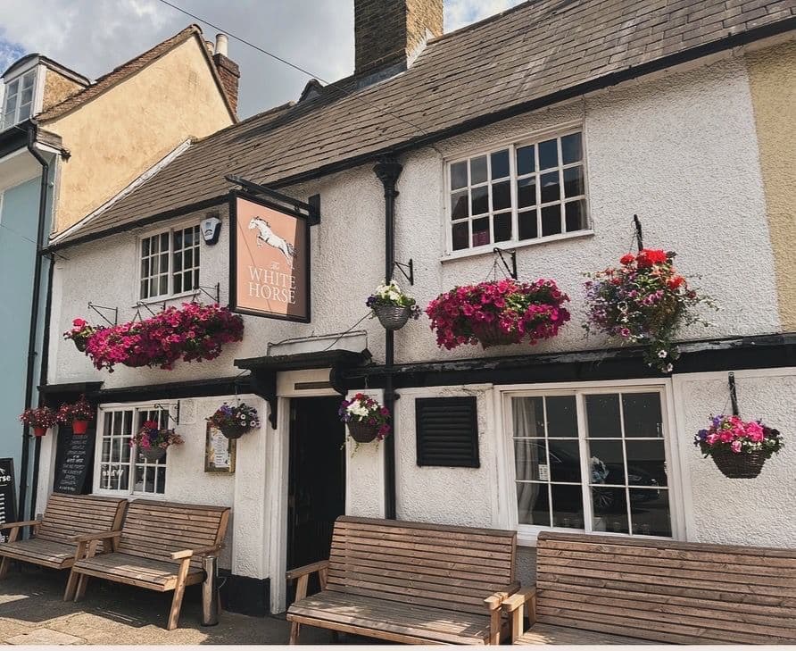 A shot of the white exterior of The White Horse pub.